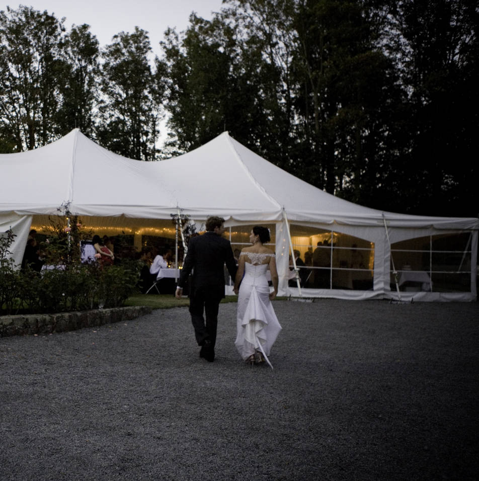 Bride and groom walk to their marquee wedding venue